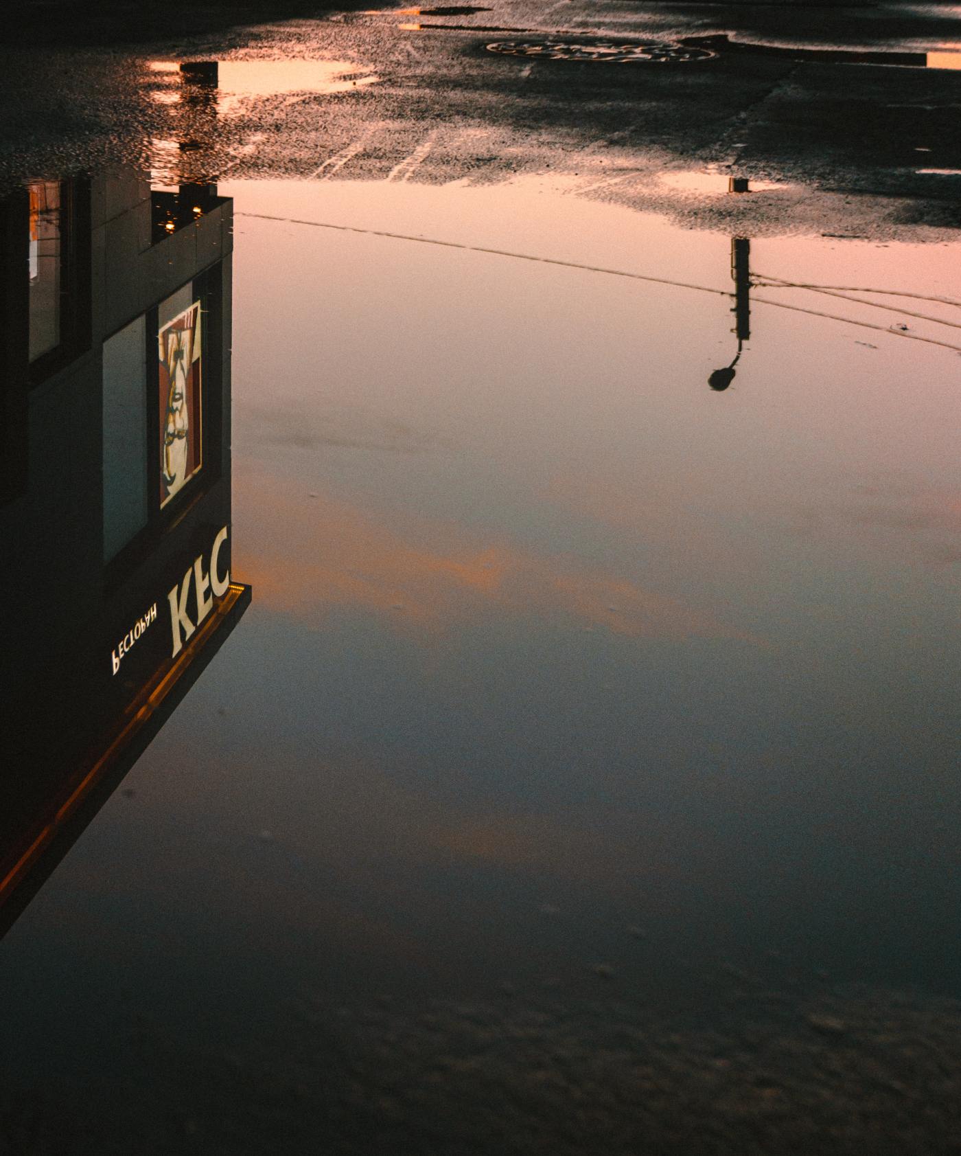 Reflection of the KFC restaurant in a pool.